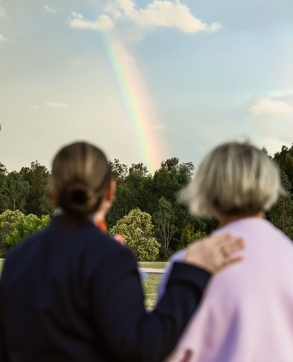 funeral director with woman looking at the rainbow