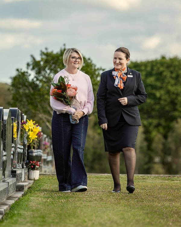 funeral director walking along side a woman